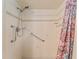 Shower with white tile, grab bars, handheld shower head, and decorative shower curtain at 10012 Sw 88Th Ct, Ocala, FL 34481
