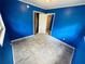 Bedroom with blue walls, light-colored tile flooring and two door frames at 1051 Se 28Th Rd, Ocala, FL 34471