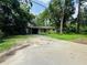 Wide view of home's exterior showing the front yard, driveway, and carport at 1051 Se 28Th Rd, Ocala, FL 34471