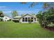 Well-maintained backyard featuring a lush lawn, lovely landscaping, and a cozy sunroom at 10806 Sw 86Th Ave, Ocala, FL 34481