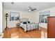 Cozy bedroom with hardwood floors, ceiling fan, and wrought iron bed frame at 10806 Sw 86Th Ave, Ocala, FL 34481