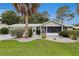Well-maintained single-story home with lush landscaping and a screened front porch at 10806 Sw 86Th Ave, Ocala, FL 34481