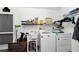 Functional laundry room with washer, dryer, utility sink, storage shelves, and exterior access at 10806 Sw 86Th Ave, Ocala, FL 34481