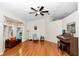 Spacious living room featuring wood floors, a bay window, and a classic piano at 10806 Sw 86Th Ave, Ocala, FL 34481