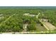 An aerial view of a single story home surrounded by lush greenery with a long driveway and ample space at 13131 Sw 73Rd St, Ocala, FL 34481