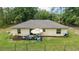 Aerial view of a home's backyard with an outdoor seating area, lush green grass, and surrounding trees at 13131 Sw 73Rd St, Ocala, FL 34481