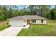 A front view of a single-story yellow home with a well manicured lawn and gray roof at 13131 Sw 73Rd St, Ocala, FL 34481