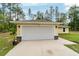 Two car garage with exterior lights on a well maintained property with a gray roof at 13131 Sw 73Rd St, Ocala, FL 34481