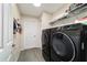 Well-lit laundry room featuring a modern black washer and dryer and convenient shelving for storage at 13131 Sw 73Rd St, Ocala, FL 34481