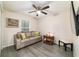 Living area features a couch, wood floors, ceiling fan, and is lit by a large window at 13131 Sw 73Rd St, Ocala, FL 34481