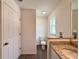 Well-lit bathroom offers a modern toilet, window, and sink with a granite countertop at 1390 Sw Obee Ridge Rd, Dunnellon, FL 34431