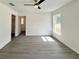 Spacious bedroom with gray wood-look flooring, ceiling fan, and views of the outdoors through a window at 1390 Sw Obee Ridge Rd, Dunnellon, FL 34431