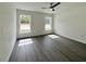 Bright bedroom with gray wood-look floors and natural light streaming through two windows at 1390 Sw Obee Ridge Rd, Dunnellon, FL 34431