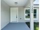 Welcoming front entrance featuring a white door, blue porch, modern fixtures, and house number at 1390 Sw Obee Ridge Rd, Dunnellon, FL 34431