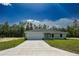 Charming single-story home featuring a two-car garage and well-maintained front lawn on a sunny day at 1390 Sw Obee Ridge Rd, Dunnellon, FL 34431