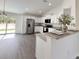 Bright kitchen featuring stainless steel appliances, white cabinetry, and gray wood-look flooring at 1390 Sw Obee Ridge Rd, Dunnellon, FL 34431