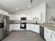 Modern kitchen with granite countertops, stainless appliances and white cabinetry at 1390 Sw Obee Ridge Rd, Dunnellon, FL 34431