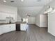 Open-concept living space with vaulted ceilings, gray flooring, and a granite-topped breakfast bar at 1390 Sw Obee Ridge Rd, Dunnellon, FL 34431