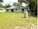 A view of the backyard featuring a grassy lawn and the exterior of the home at 13921 Sw 108Th Ln, Dunnellon, FL 34432