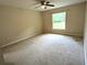Spacious bedroom featuring neutral carpet, a ceiling fan, and a window for natural light at 13921 Sw 108Th Ln, Dunnellon, FL 34432