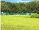 Grassy field views a tennis court; perfect spot for outdoor recreation at 13921 Sw 108Th Ln, Dunnellon, FL 34432