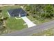 Aerial view of a charming single-story home with a blue garage door, gray exterior and concrete driveway at 142 Guava Pass, Ocklawaha, FL 32179