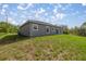 This home features a spacious backyard with a grassy area and a sliding glass door entrance at 142 Guava Pass, Ocklawaha, FL 32179