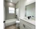 Well-lit bathroom featuring modern fixtures, a bathtub with tile surround, and stylish vanity at 142 Guava Pass, Ocklawaha, FL 32179