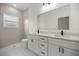 Elegant bathroom featuring double vanity, white cabinets, modern fixtures, and a tiled walk-in shower at 142 Guava Pass, Ocklawaha, FL 32179