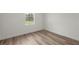 Neutral bedroom with wood-look floors, natural light, and a view of the outdoors at 142 Guava Pass, Ocklawaha, FL 32179