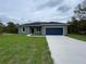 Charming single-story home with a well-maintained lawn and a two-car garage at 142 Guava Pass, Ocklawaha, FL 32179