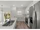 This modern kitchen features white cabinets, stainless steel appliances, and a center island with a sink at 142 Guava Pass, Ocklawaha, FL 32179