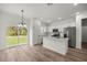 Open concept kitchen featuring white cabinets, stainless steel appliances, and an adjacent dining area at 142 Guava Pass, Ocklawaha, FL 32179