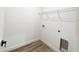 A compact laundry room with wood-style floors offers a practical and efficient space at 142 Guava Pass, Ocklawaha, FL 32179