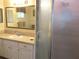 Bathroom vanity with mirror and sink next to a glass door shower with neutral tan colors at 14695 Sw 112Th Cir, Dunnellon, FL 34432