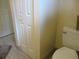 Bathroom with a clean toilet, white door, and wall, offering a functional space at 14695 Sw 112Th Cir, Dunnellon, FL 34432