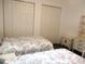Bedroom featuring twin beds with floral comforters and closet with double doors at 14695 Sw 112Th Cir, Dunnellon, FL 34432
