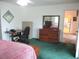 Bright bedroom features a desk, dresser, and soft green carpet, offering a comfortable space at 14695 Sw 112Th Cir, Dunnellon, FL 34432