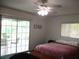 Bedroom with ceiling fan and sliding glass doors to the outdoor seating area, lots of natural light at 14695 Sw 112Th Cir, Dunnellon, FL 34432