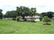 Home exterior featuring a spacious backyard with beautiful landscaping and mature trees at 14695 Sw 112Th Cir, Dunnellon, FL 34432