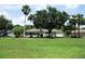 Home exterior showcasing a large yard with vibrant green grass and lush tropical landscaping at 14695 Sw 112Th Cir, Dunnellon, FL 34432
