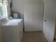 Practical laundry room with a washer, dryer, storage cabinets, and a convenient door, maximizing functionality at 14695 Sw 112Th Cir, Dunnellon, FL 34432
