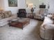 Comfortable living room featuring sofas, armchairs, and a glass-top coffee table at 14695 Sw 112Th Cir, Dunnellon, FL 34432