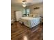 Comfortable bedroom featuring a large bed with patterned bedding, hardwood floors, and natural light at 16023 Sw 14Th Avenue Rd, Ocala, FL 34473