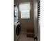 Functional laundry room with stackable washer and dryer, complemented by a louvered door and window at 16023 Sw 14Th Avenue Rd, Ocala, FL 34473