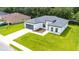 Aerial view of house with modern design, green lawn, landscaped garden and long driveway at 162 Nw 42Nd Pl, Ocala, FL 34475