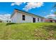 View of the back of the home and backyard, with a sliding glass door and green lawn at 162 Nw 42Nd Pl, Ocala, FL 34475