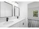 Elegant bathroom featuring dual sinks with modern black fixtures, white cabinetry, and quartz countertops at 162 Nw 42Nd Pl, Ocala, FL 34475