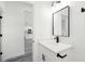 Bathroom boasts a white vanity with black hardware, modern fixtures, and gray floors at 162 Nw 42Nd Pl, Ocala, FL 34475