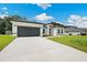 Charming single-story home with a well-manicured lawn and a long driveway leading to a garage at 162 Nw 42Nd Pl, Ocala, FL 34475